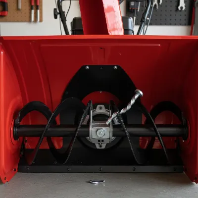 A snow blower auger assembly with a highlighted snapped shear pin, illustrating a common problem.